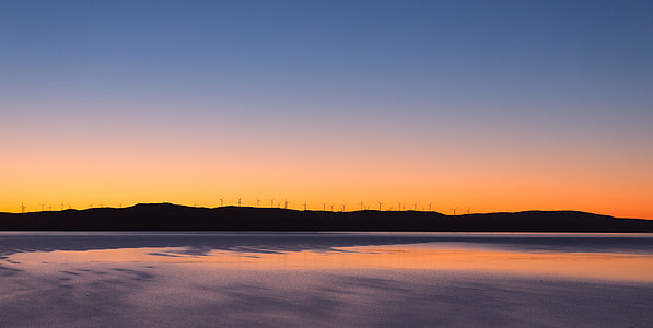 silhouette of mountains near body of water thumbnail