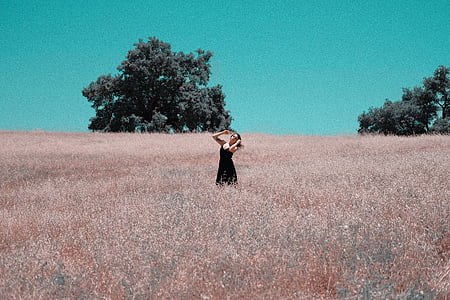woman wearing black dress standing on the grass field thumbnail