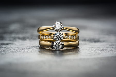 three gold-colored clear gemstone on concrete surface thumbnail