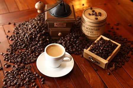 cup of coffee beside coffee beans and coffee grinder thumbnail