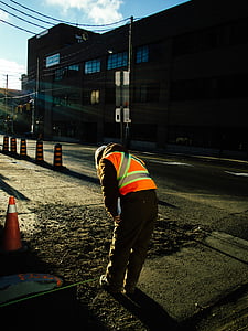 person wearing reflectorized vest standing near traffic cone thumbnail
