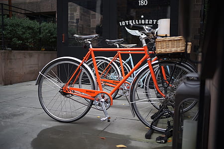 orange and black road bicycle on gray road thumbnail