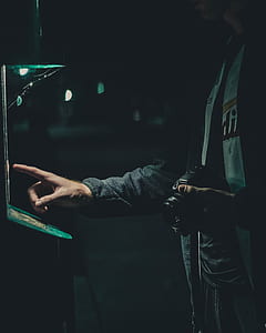 person holding black DSLR camera using green lighted machine thumbnail