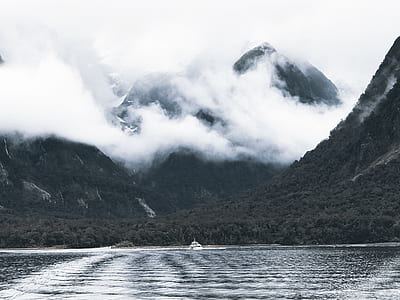 Photography of Body of Water Surrounded by Mountains and Fogs thumbnail