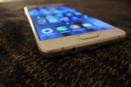 white Samsung smartphone on gray textile thumbnail