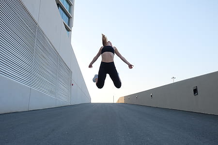 Woman Wearing Black Crop Top Jumping Beside the Building thumbnail