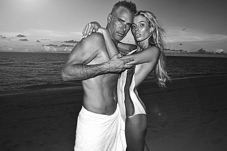 grayscale photography of man and woman standing near body of water thumbnail