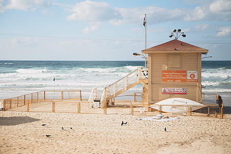 white wooden lifeguard watchtower on beach thumbnail
