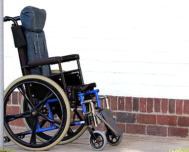 black and blue wheelchair parked near wall thumbnail