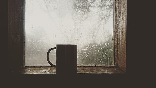 person taking photo of white ceramic mug on window thumbnail
