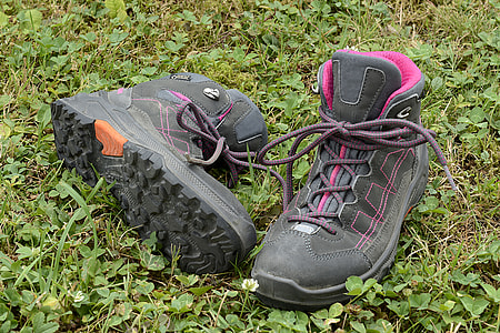 black-and-pink lace-up boots on green grass field close-up photo thumbnail