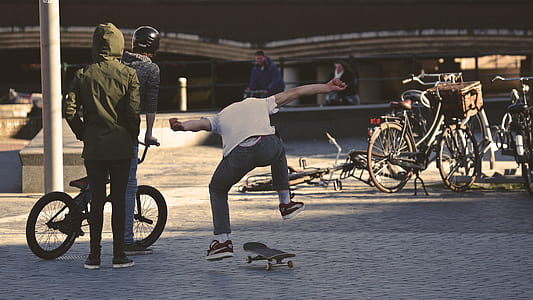 Man in White Shirt Doing Skateboard Trick thumbnail