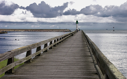 empty brown wooden dock bridge with lighthouse tower thumbnail