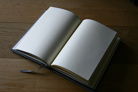 white book on top of brown wooden surface thumbnail