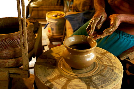 person making brown clay pot thumbnail