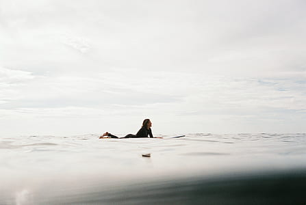 woman riding on surfboard during daytime thumbnail