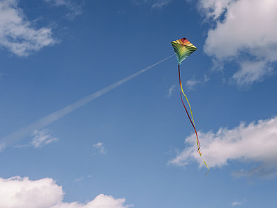 green and yellow kite under blue cloudy sky thumbnail