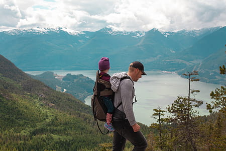 Man Walking on Top of Mountain Under Blue Sky thumbnail