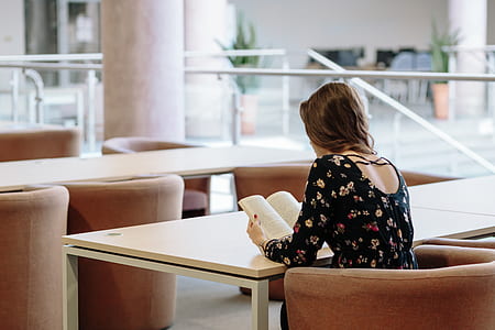 woman in black long-sleeved top reading a book thumbnail