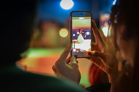 person taking picture of man and woman dancing on stage thumbnail