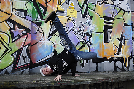 man doing head stand near graffiti wall thumbnail