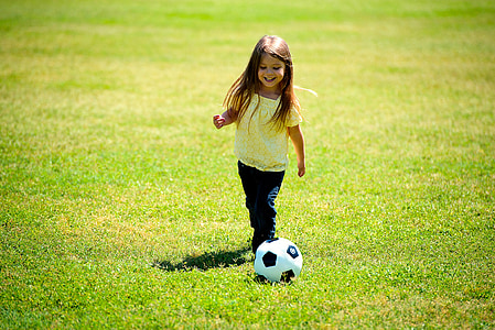 toddler girl playing soccer during daytime thumbnail
