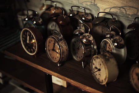 assorted round gray metal alarm clocks on table thumbnail