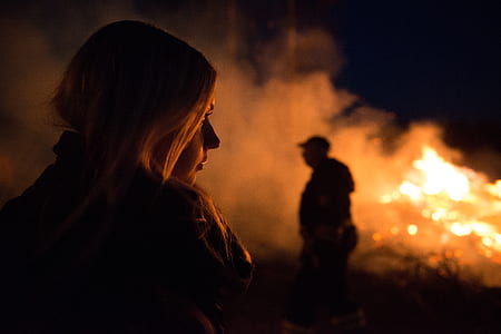shallow focus photography of woman looking at fire thumbnail