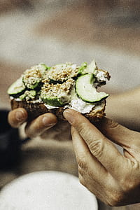 Person Holding Bitten Bread With Green Vegetables thumbnail