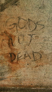 gray concrete surface with God's Not Dead handwritten text thumbnail