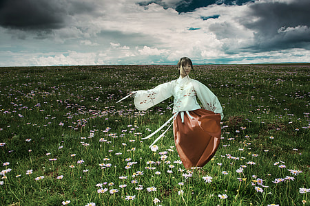 woman in white and brown kimono standing in garden with white daisies thumbnail
