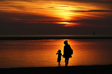 silhouette of woman and girl on the shore thumbnail