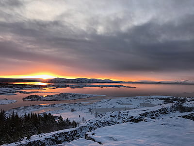 body of water covered with snow during sunset thumbnail