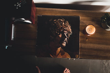 Man Wearing Brown Collared Shirt Photo on Brown Wooden Cabinet thumbnail