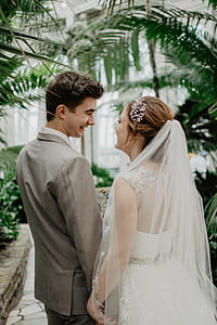 groom and bride standing near plants thumbnail