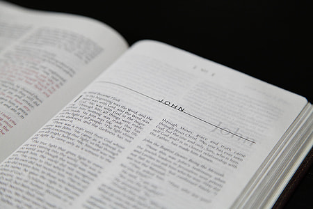 book opened at John page resting on black surface thumbnail