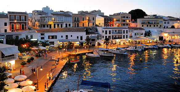 boats by the dock near buildings under white sky at daytime thumbnail