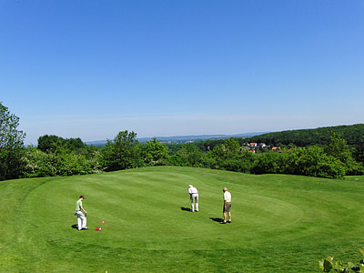 three men playing golf in golf field during daytime thumbnail