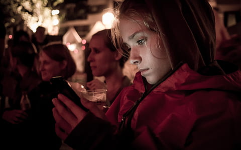 woman in red jacket holding smartphone thumbnail