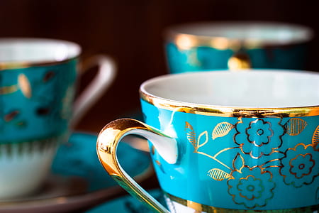 selective focus photography of gold and blue floral mug and saucer thumbnail