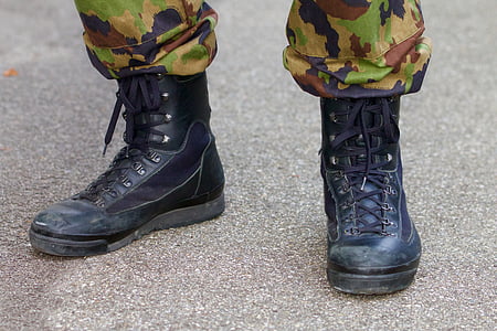 person wearing black leather combat boots standing on the ground thumbnail
