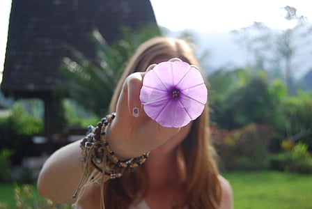 woman holding purple petaled flower thumbnail