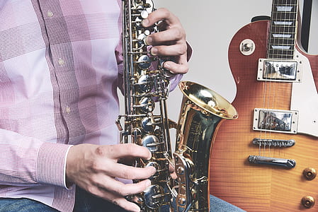 person plying brass-colored saxophone thumbnail