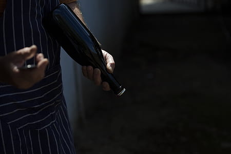 person holding amber glass beverage bottle thumbnail