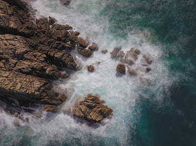 brown rocks surrounded by ocean during daytime thumbnail