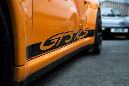 orange car on gray concrete floor thumbnail