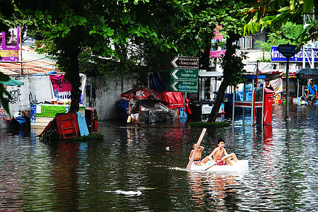 two boys riding boat near green trees during daytime thumbnail