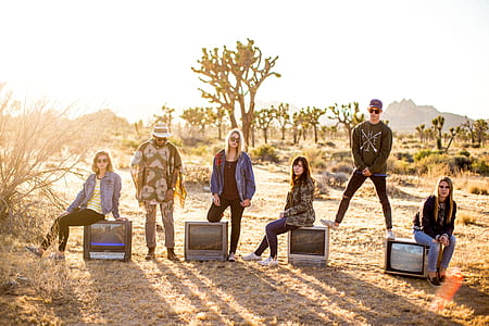 photograph of group of people seating on CRT televisions thumbnail