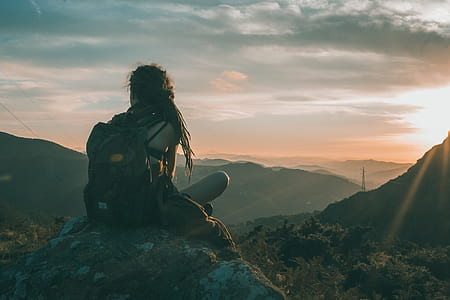 woman sitting on rock during sunrise thumbnail