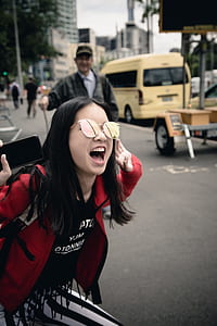 girl wearing mirrored sunglasses shouting on street thumbnail